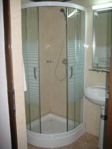 a shower with a glass door next to a sink at Hotel Traian Eforie Nord in Eforie Nord