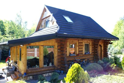 a log cabin with a solar roof at CHATA PACHNĄCA LASEM in Andrychów
