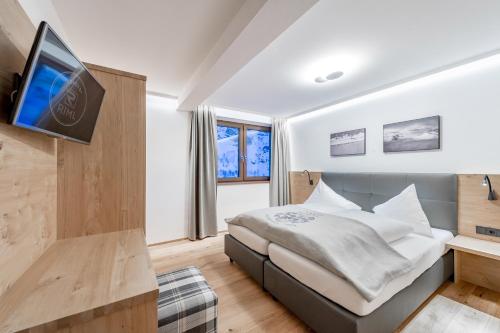 ein Schlafzimmer mit einem Bett und einem TV an der Wand in der Unterkunft Piccard Nº 5 in Obergurgl