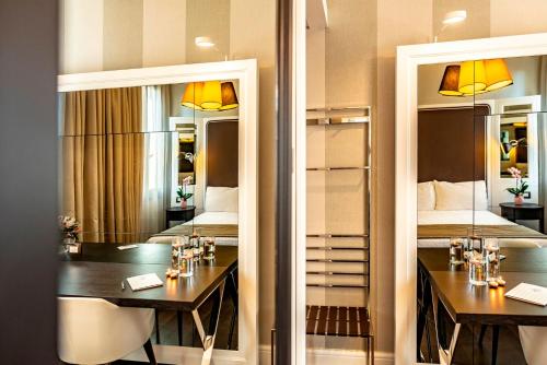 a room with two beds and two tables and mirrors at Hotel Grande Italia in Chioggia