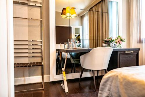 a bedroom with a dining room table and a mirror at Hotel Grande Italia in Chioggia
