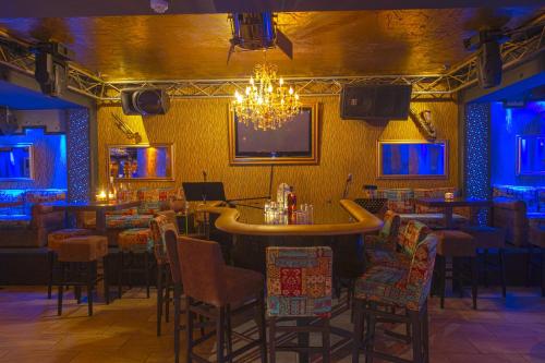 a bar in a restaurant with chairs and a chandelier at Spa Hotel Spartak in Sandanski