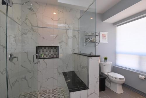 a bathroom with a glass shower with a toilet at The SoMa Furnished Residences in Hamilton