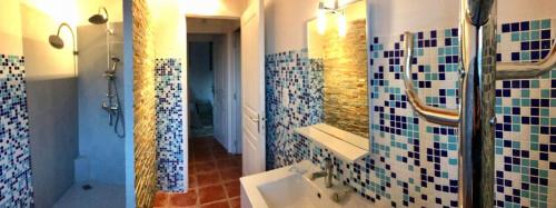 La salle de bains est pourvue de murs carrelés bleus et blancs et d'un lavabo. dans l'établissement Casa ilicia, à Eus