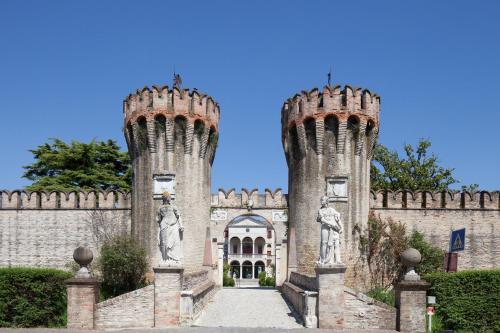 ein Schloss mit zwei Türmen mit Statuen drauf in der Unterkunft Castello di Roncade in Roncade