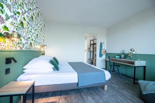 a hotel room with a bed and a desk at Center Parcs Les Bois Francs in Verneuil d'Avre et d'Iton