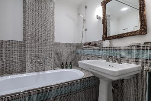 a bathroom with a sink and a tub and a mirror at Milano Antica Apartment in Milan
