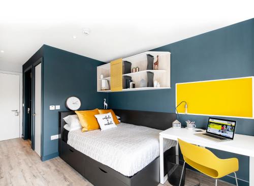 a bedroom with a bed and a desk with a laptop at Yugo Explore - Amnis House in Cork