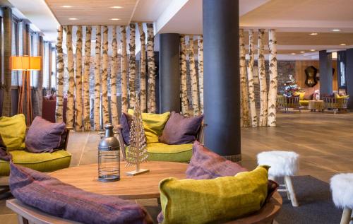 a room with a table and yellow and purple chairs at Résidence Club MMV L'Altaviva in Tignes