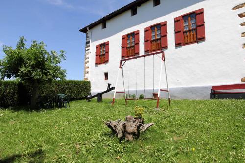 a yard with a swing in front of a building at Casa Katton in Etxalar