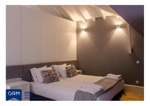 a bedroom with two beds and lights on the wall at ORM Praça Apartment in Porto