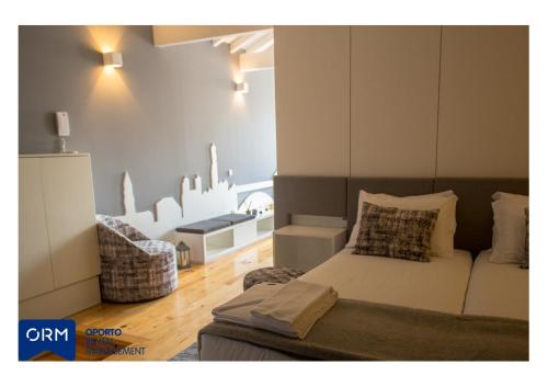 a bedroom with a bed and a chair in it at ORM Praça Apartment in Porto