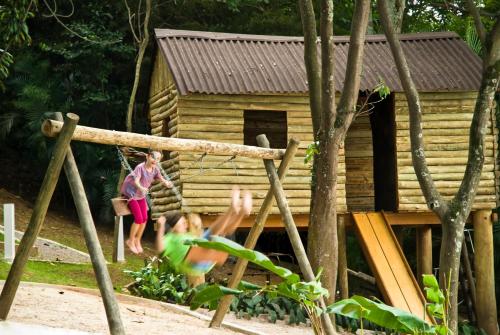 two children playing in front of a log cabin at Novotel Sao Paulo Morumbi in Sao Paulo