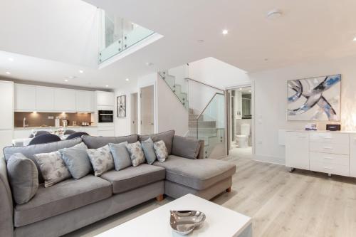a living room with a couch and a kitchen at Citystay Living - Midsummer Mews in Cambridge