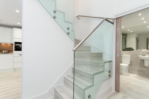 a glass staircase in a bathroom with a sink at Citystay Living - Midsummer Mews in Cambridge