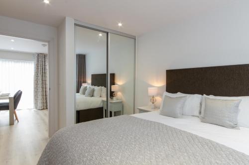 a bedroom with a large white bed and a desk at Citystay Living - Midsummer Mews in Cambridge