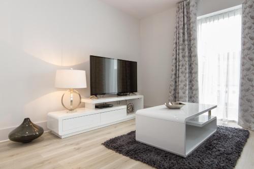 a white living room with a flat screen tv at Citystay Living - Midsummer Mews in Cambridge