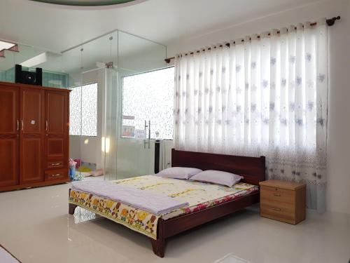 a bedroom with a bed and a large window at Minh Kim Guesthouse in Ấp Phó