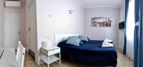 a bedroom with a blue bed in a white room at B&B Valverde in Verona