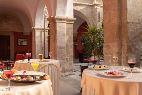 two tables with plates of food and glasses of wine at Izan Trujillo in Trujillo