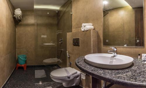 a bathroom with a sink and a toilet at Hotel Suktara International in Siliguri
