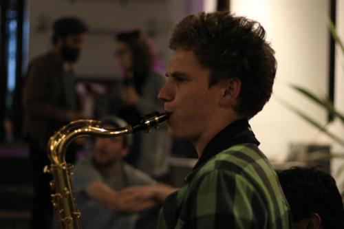 a man playing a saxophone in a room at El Yarumo Hostel in Bogotá