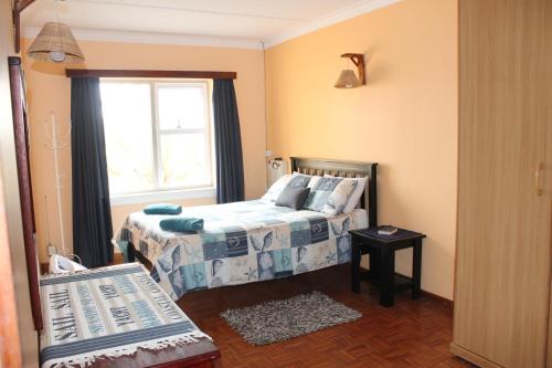Schlafzimmer mit einem Bett und einem Fenster in der Unterkunft The Timeless Way Self Catering Accommodation in Swakopmund