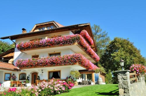 a house with flowers on the side of it at Boutique Pension Erlacher - Adults Only in Villandro