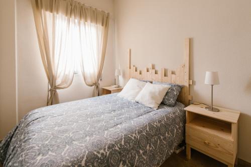 Schlafzimmer mit einem Bett mit blauer Decke in der Unterkunft Alameda Amor Suite by Valcambre in Sevilla