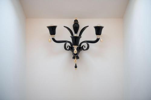 a chandelier hanging on a white wall at Ca' Bonfadini Historic Experience in Venice