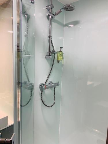 a shower with a hose and a shower head at easyHotel London City Shoreditch in London