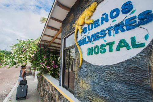 a sign for a seafood restaurant with a woman standing outside at Hostal Sueños Silvestres in Puerto Ayora