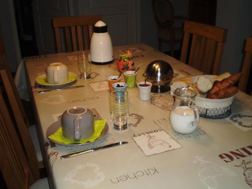 Una mesa con un mantel con comida y leche. en Les Roziers - Roulotte, en Bagnac