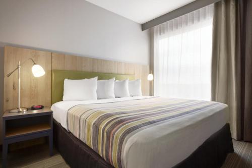 a large bed in a hotel room with a window at Country Inn & Suites by Radisson, Seattle-Bothell, WA in Bothell