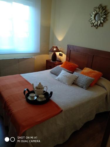 Un dormitorio con una cama con una bandeja de comida. en Calle Maliayo, en Villaviciosa