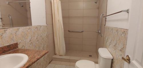 y baño con ducha, aseo y lavamanos. en Travel Eagle Inn Motel en Long Beach
