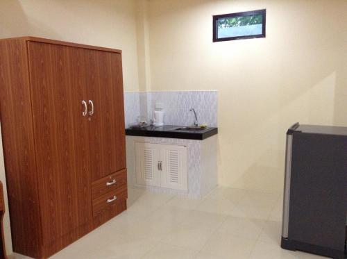 a bathroom with a sink and a wooden cabinet at Wattana Bungalow in Nai Yang Beach