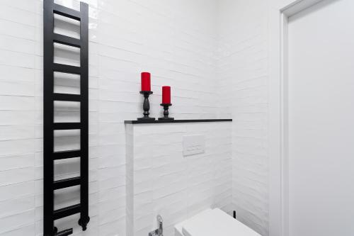 a bathroom with a toilet and two red candles at Ludwinowska11 Apartments in Kraków