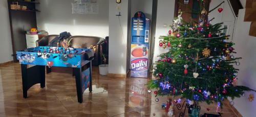 a christmas tree in a living room with a table and a soda bottle at Casa Adina in Sinaia