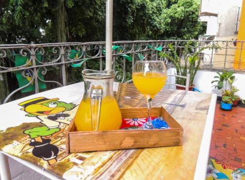 a wooden tray with a glass of orange juice on a table at Hostel Recanto de Alegrias em São Cristòvão in Rio de Janeiro