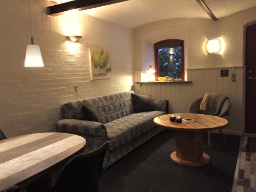 a living room with a couch and a table at Lille Degnbøl in Degnbøl