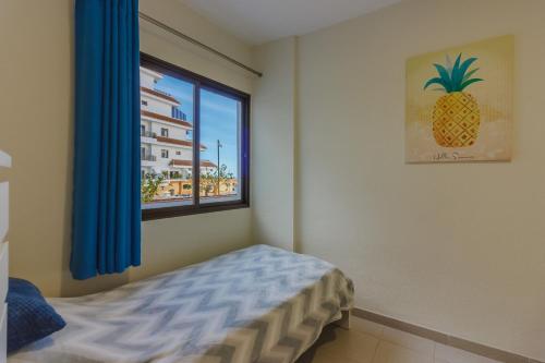 1 dormitorio con una ventana con una foto de piña en Seguro Spacious apartment with roomy terrace, en Puerto de Santiago