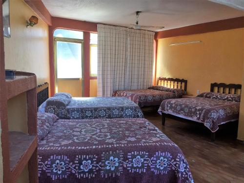 una camera d'albergo con due letti e una finestra di Hotel Olimar ad Acapulco