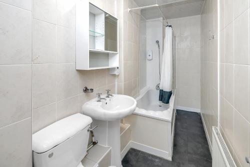 a white bathroom with a sink and a toilet at Flexistay Tulsi Aparthotel in Croydon