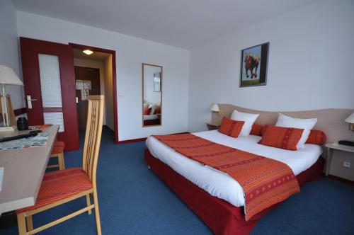 a hotel room with a large bed and a desk at Le Relais De La Vallee in Hyèvre-Paroisse