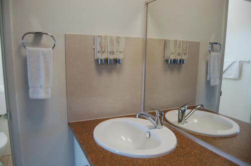 a bathroom with two sinks and a mirror at Slipway Hotel Motel in Ballina