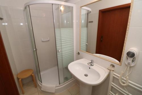 a bathroom with a sink and a shower at Hotel Adria in Rumia