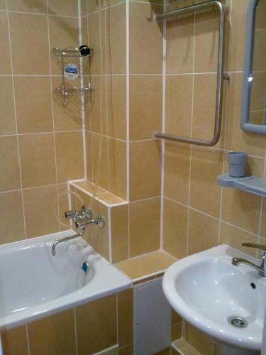 a bathroom with a shower and a sink and a tub at Готель. Квартири подобово in Yuzhnoukrainsk 