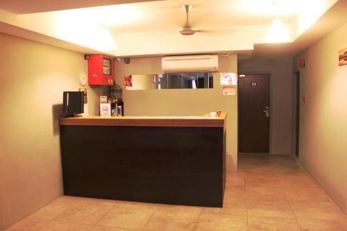 a kitchen with a black counter and a hallway at T Hotel in Tawau