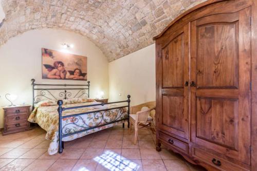 1 dormitorio con 1 cama y puerta de madera grande en Residenze San Paolo, en Ragusa